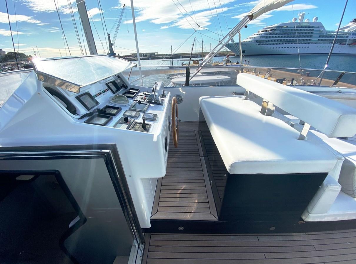 a deck with a deck and a large ship in the water aboard PETARDO C Yacht for Sale