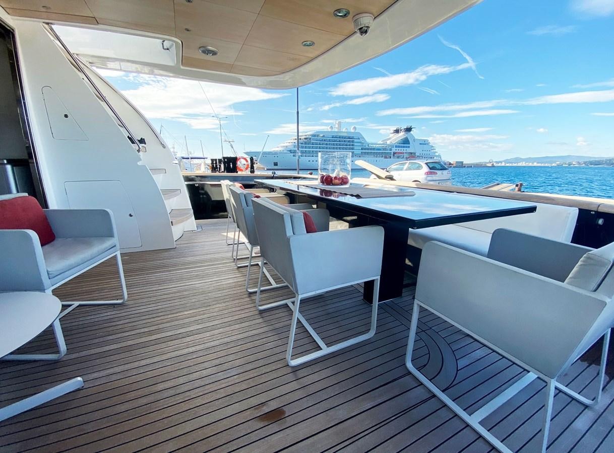a deck with a table and chairs on it aboard PETARDO C Yacht for Sale