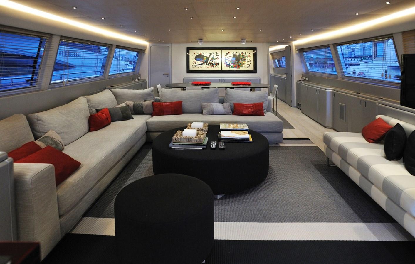 a living room with a large white couch and a black coffee table aboard PETARDO C Yacht for Sale