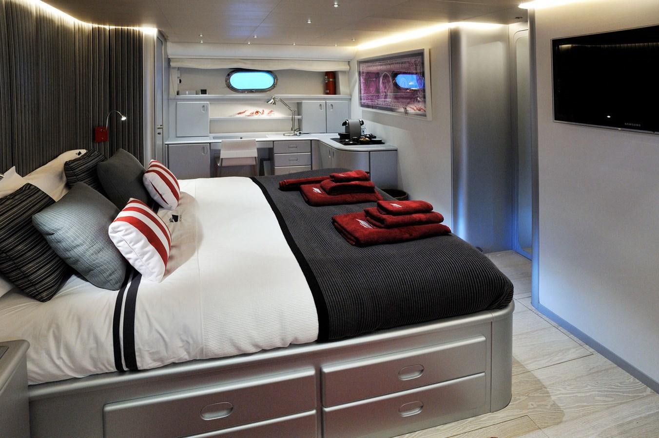 a bed with a black sheet and red and white pillows aboard PETARDO C Yacht for Sale