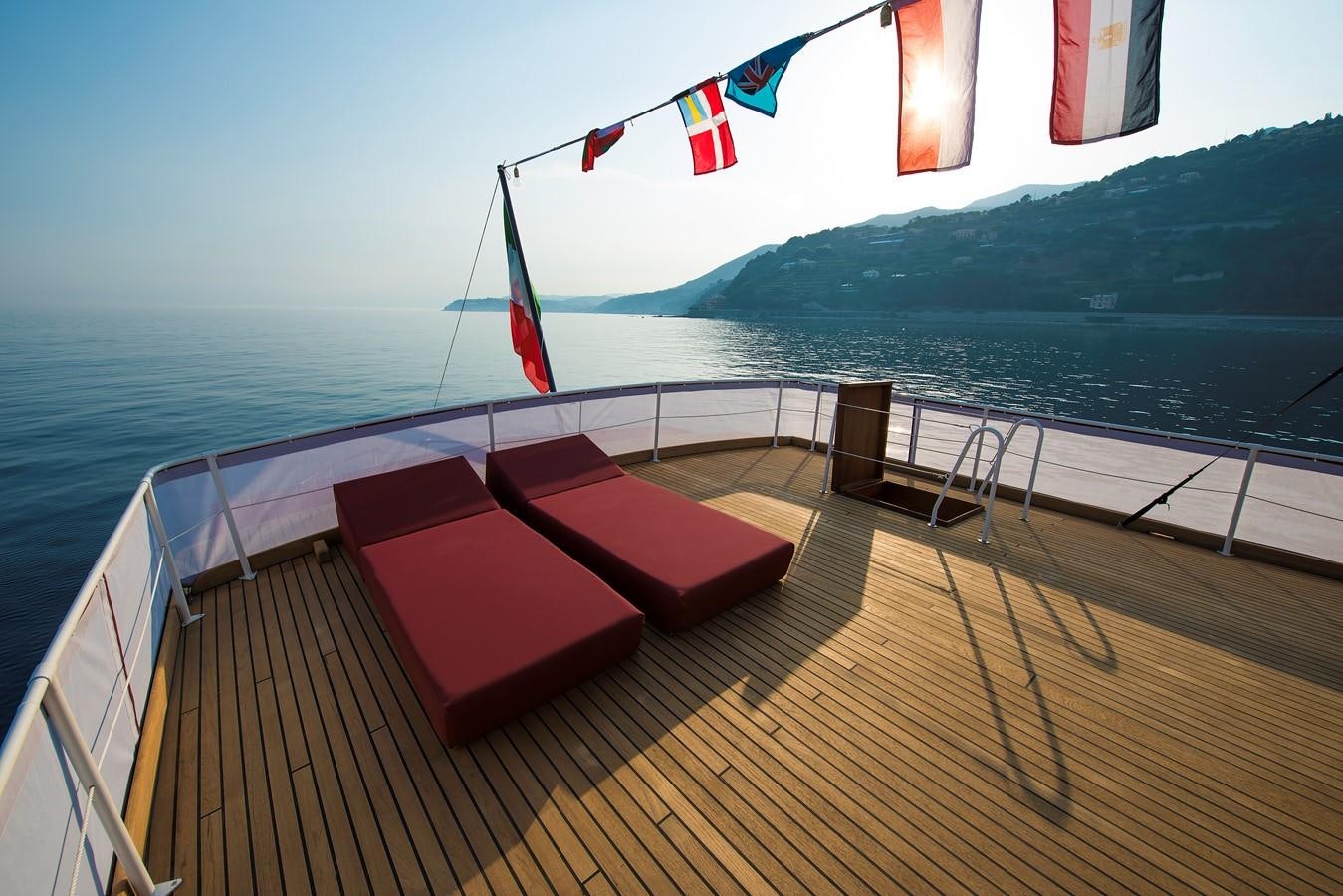 a deck with a view of the ocean and mountains aboard EMERALD Yacht for Sale