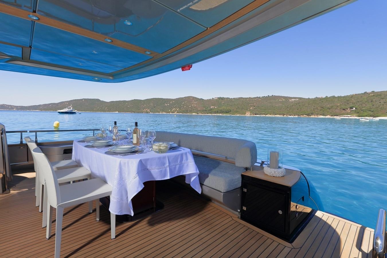 a table and chairs on a deck overlooking a body of water aboard BLACK PEARL AJACCIO Yacht for Sale