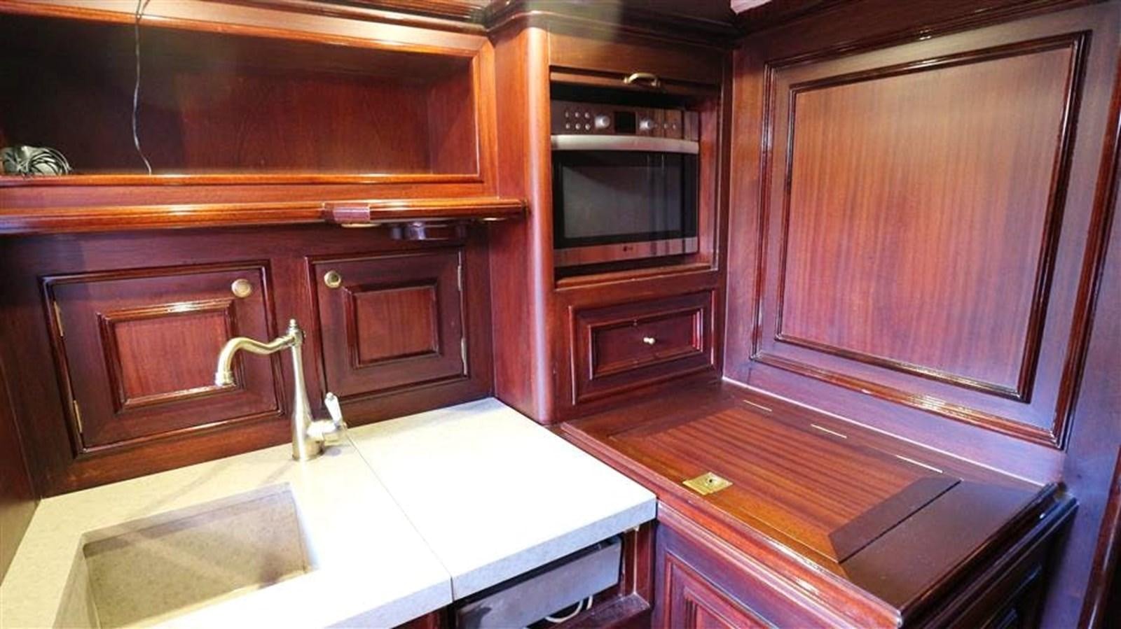 a kitchen with wooden cabinets aboard SKY Yacht for Sale