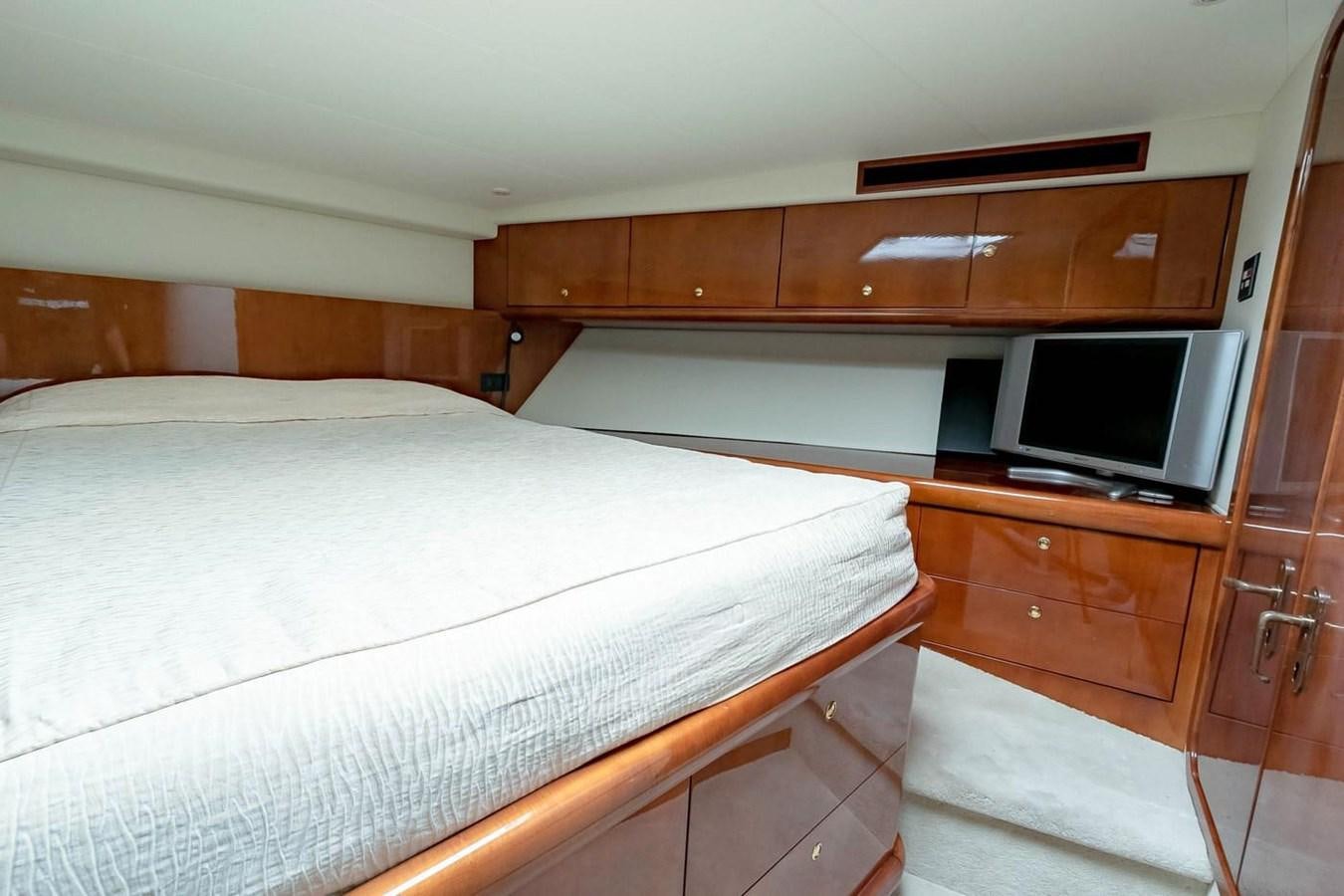 a bedroom with a bed and cabinets aboard PURELY PLEASURE Yacht for Sale