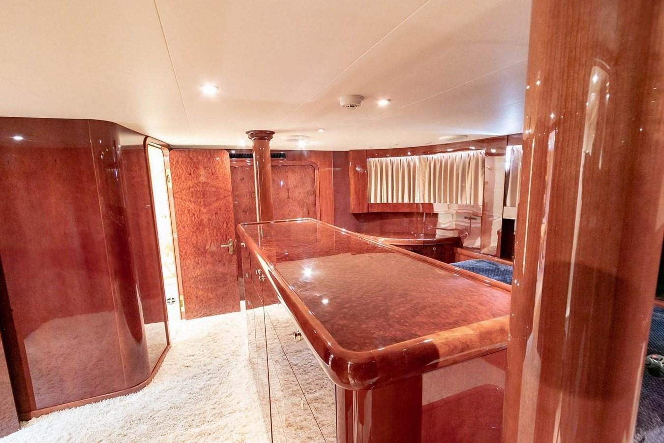a room with a bed and a table aboard PURELY PLEASURE Yacht for Sale