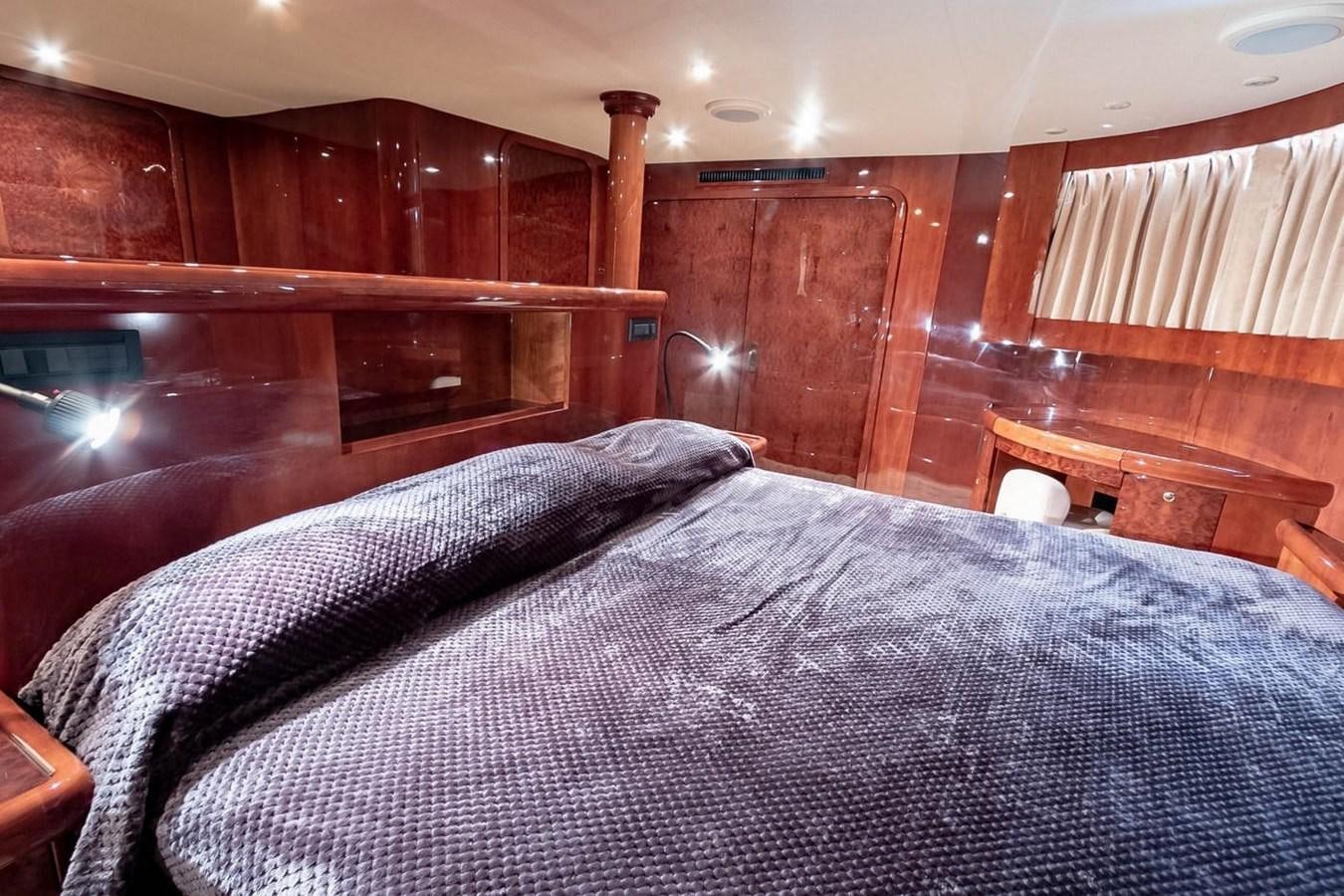 a bed with a wooden headboard aboard PURELY PLEASURE Yacht for Sale