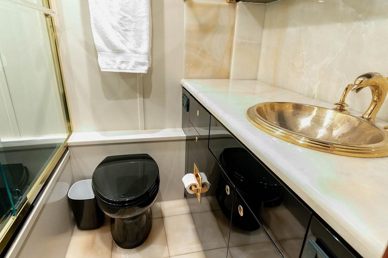 a bathroom with a sink and trashcan aboard PURELY PLEASURE Yacht for Sale