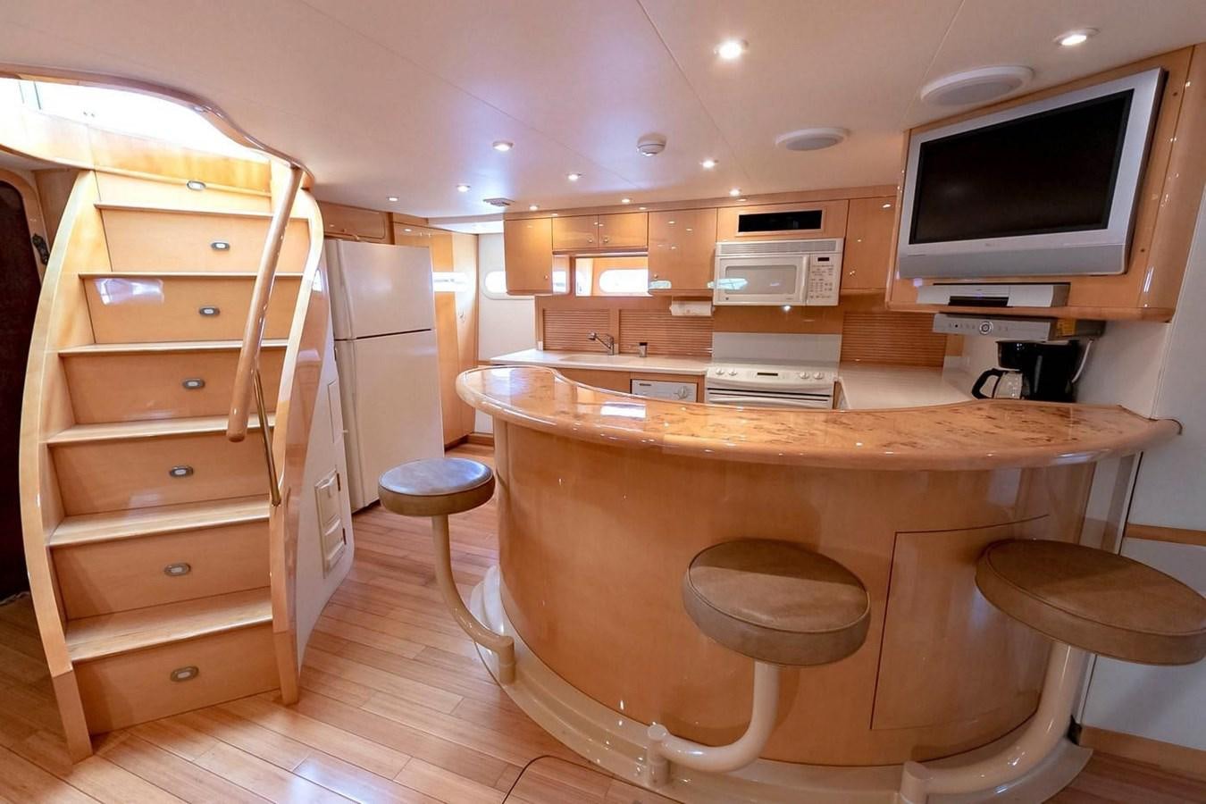 a kitchen with a table and stools aboard PURELY PLEASURE Yacht for Sale