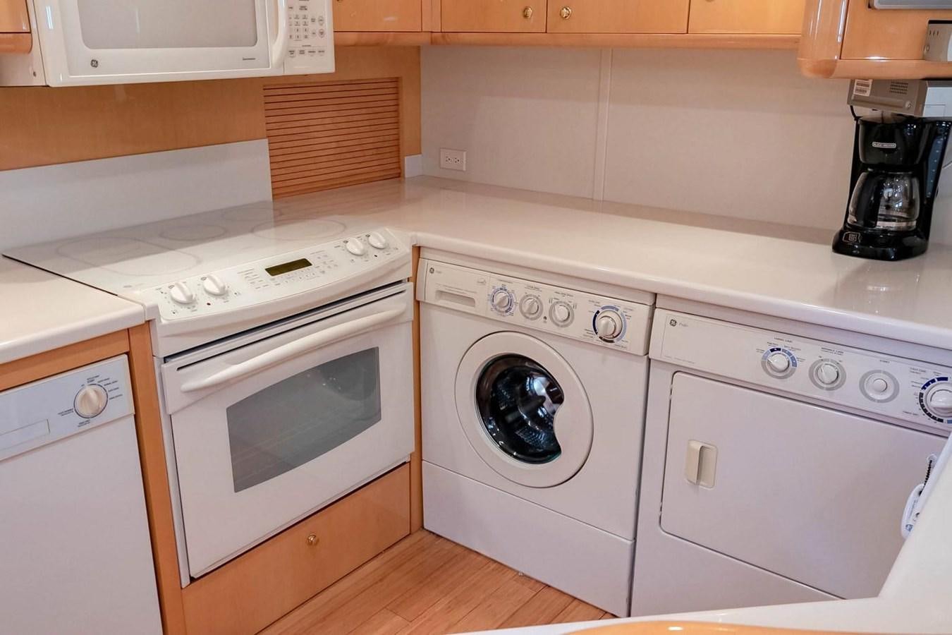 a kitchen with white appliances aboard PURELY PLEASURE Yacht for Sale