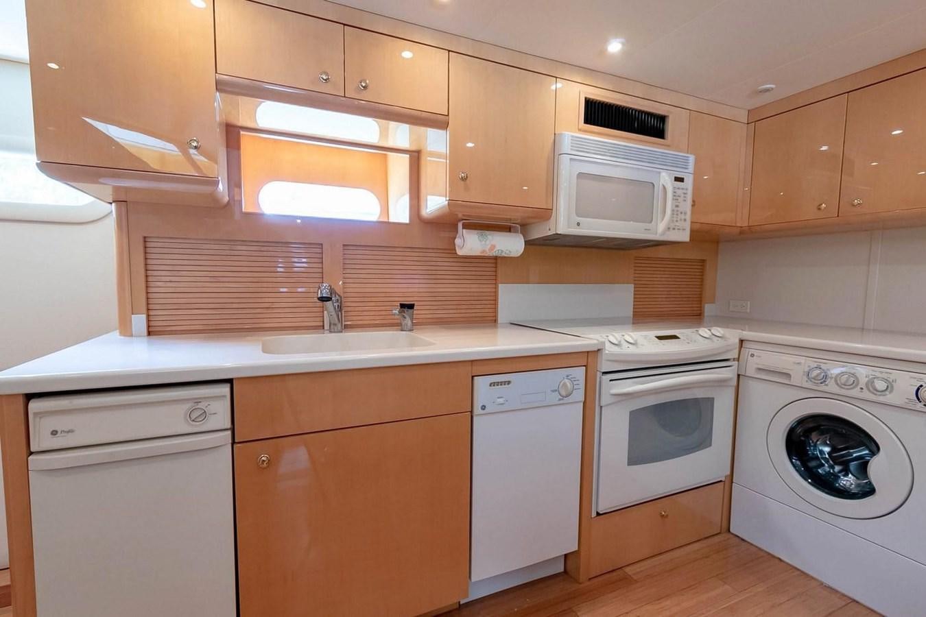 a kitchen with wooden cabinets aboard PURELY PLEASURE Yacht for Sale