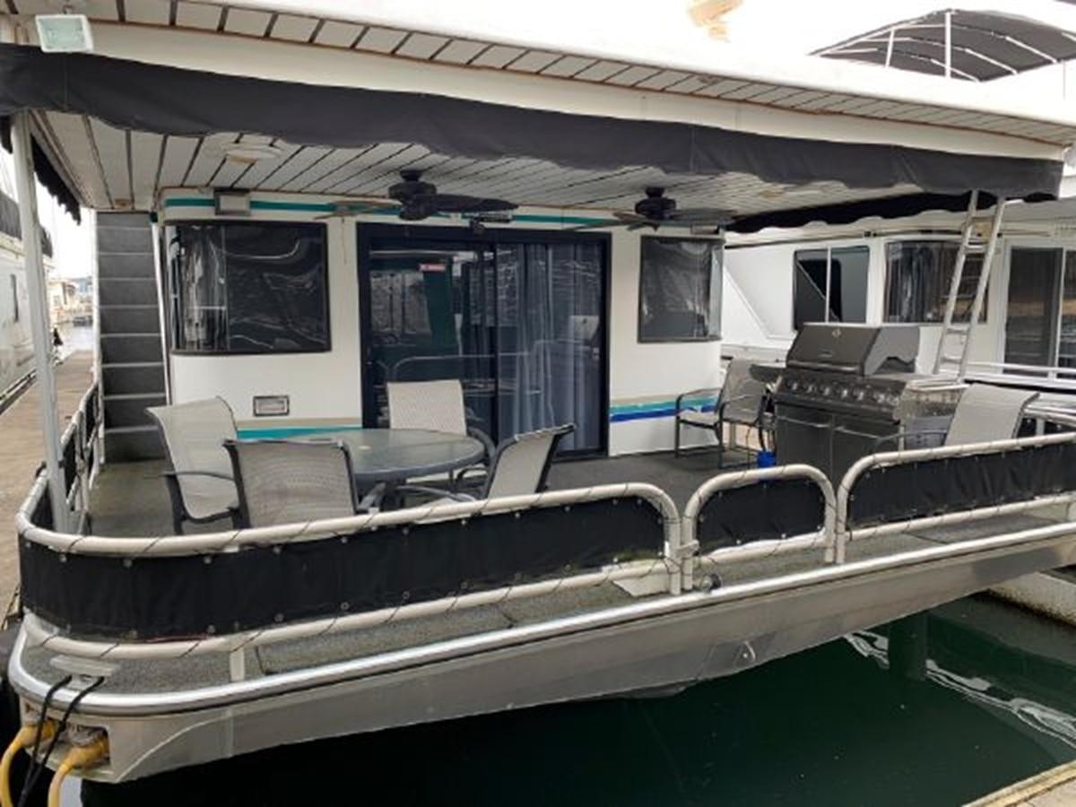 a boat with a deck and chairs aboard SUMERSET HOUSEBOAT Yacht for Sale