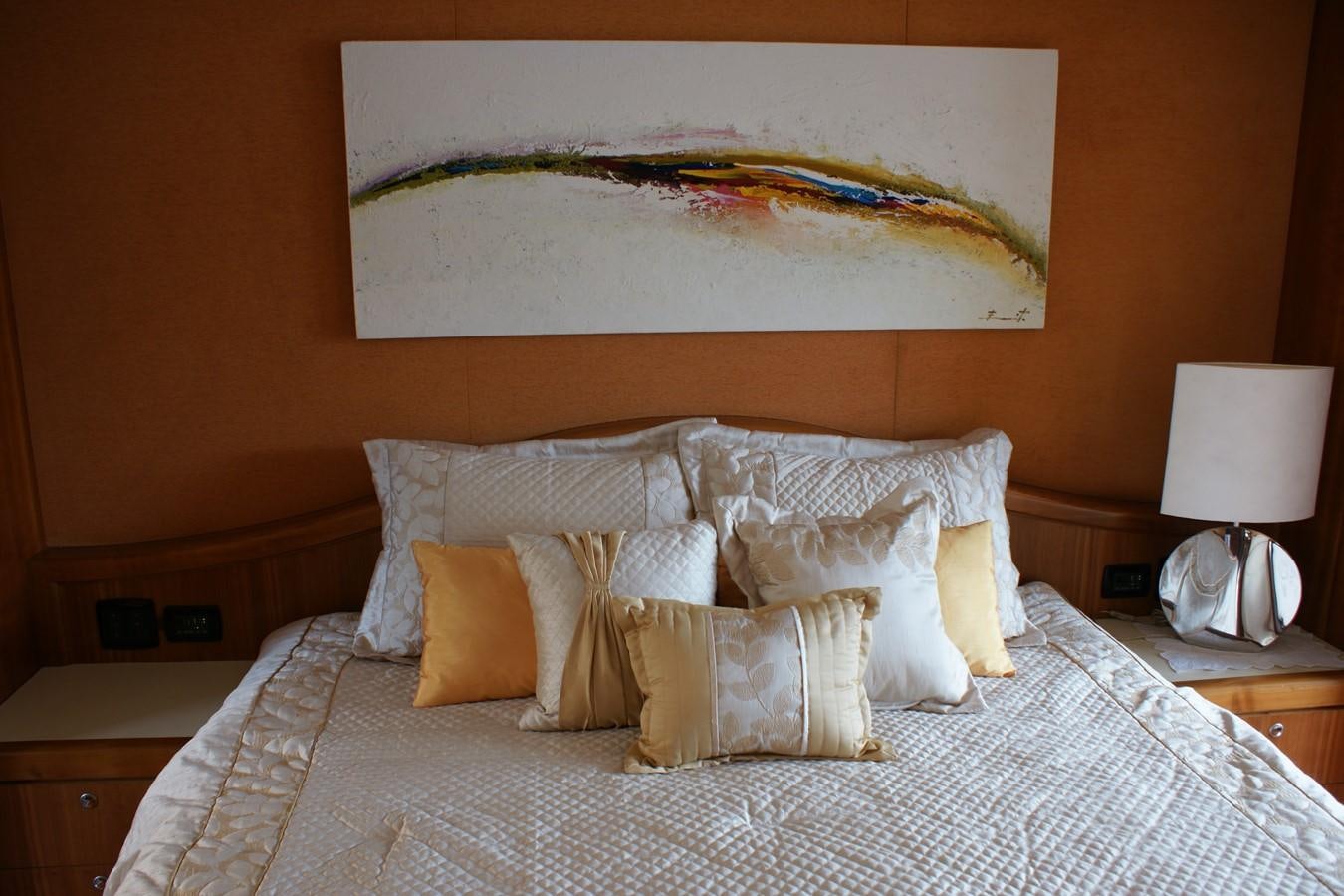 a bed with a painting above it aboard FORTALEZA Yacht for Sale