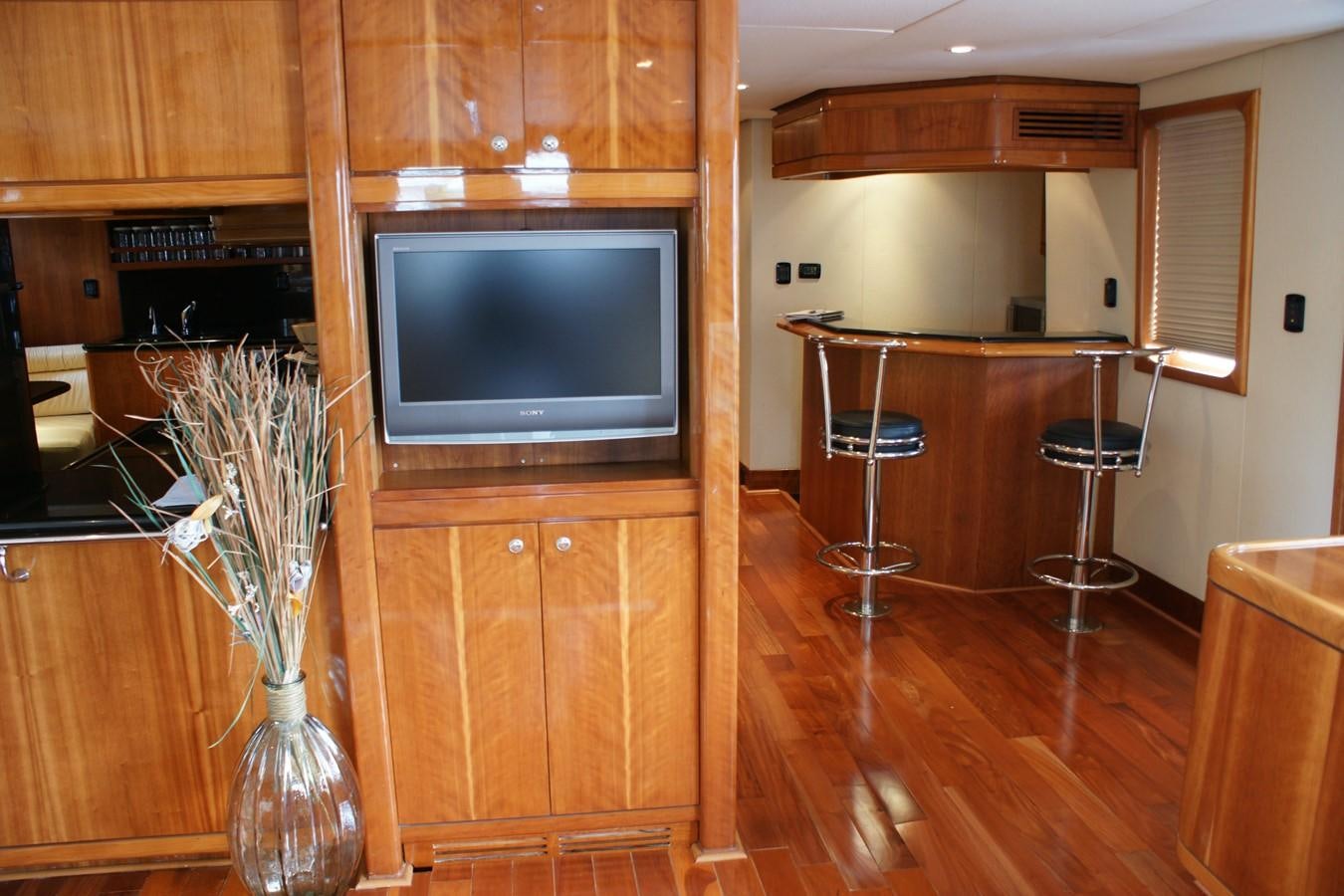 a living room with a tv and a table aboard FORTALEZA Yacht for Sale