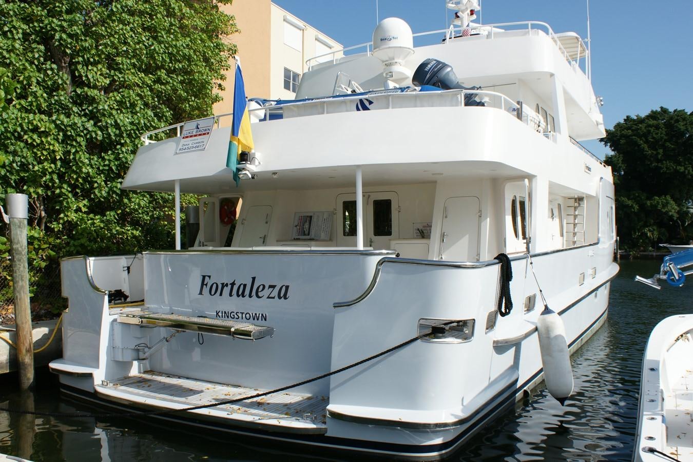 a white boat in a harbor aboard FORTALEZA Yacht for Sale