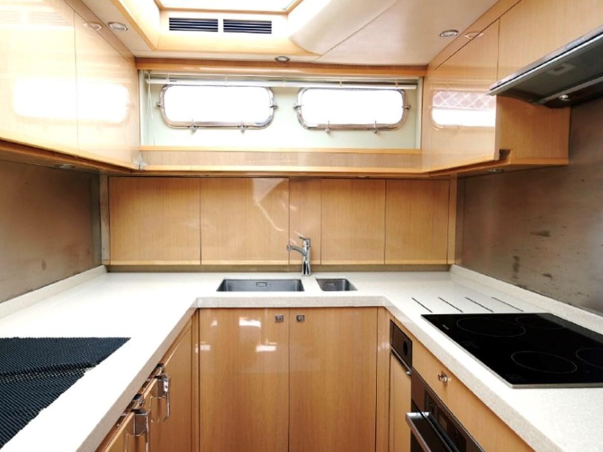 a kitchen with wooden cabinets aboard PRINCESS V85 Yacht for Sale