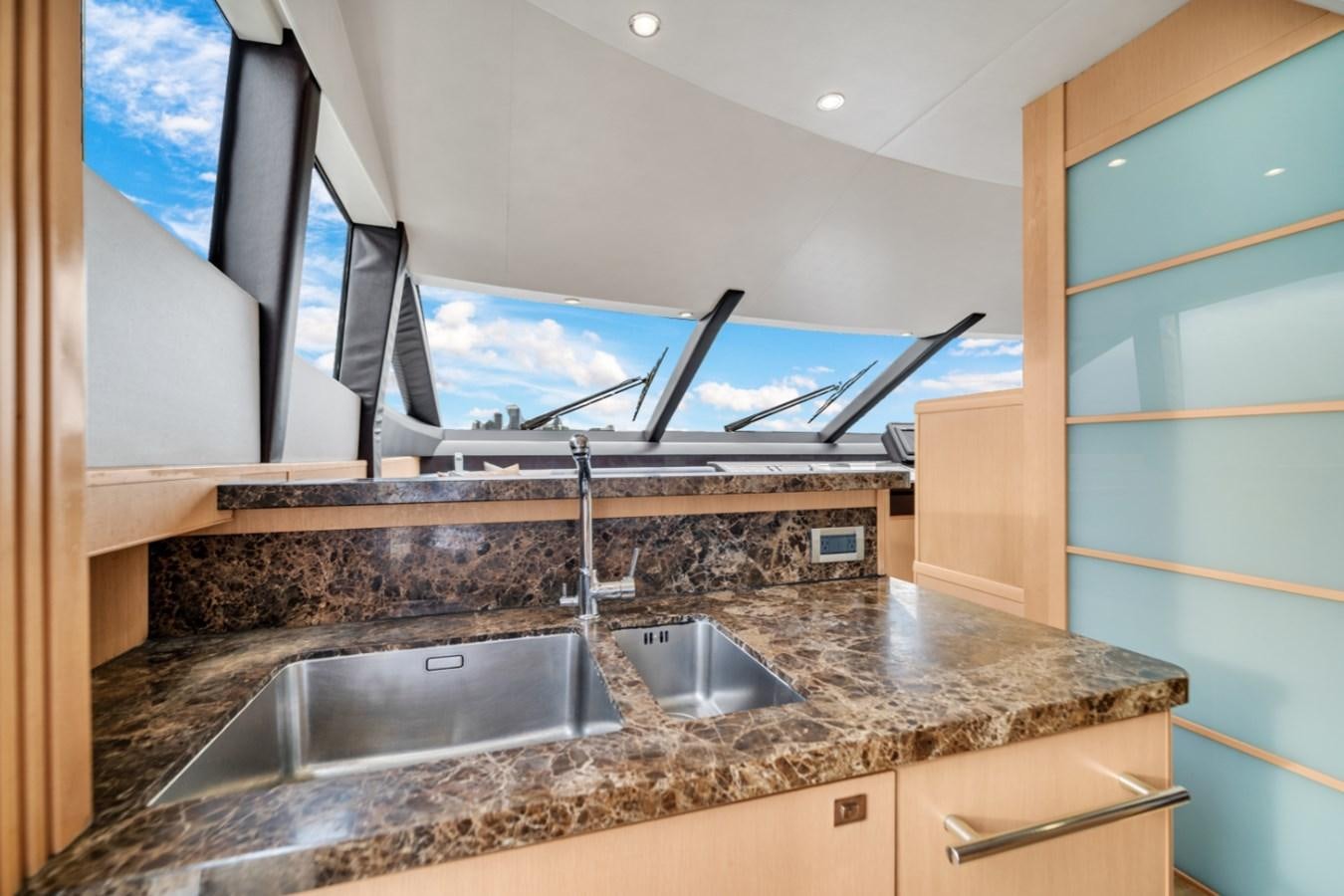 a kitchen with a large marble counter top and a large window aboard PRINCESS 85 MY Yacht for Sale