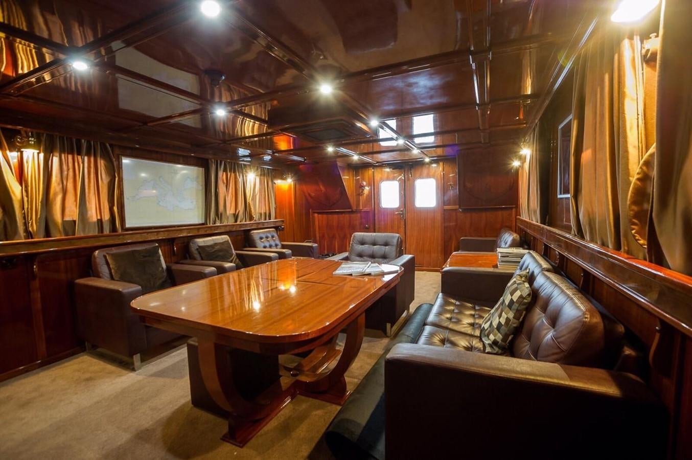a room with a table and couches aboard ANNA I Yacht for Sale