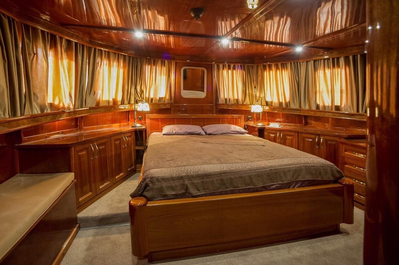 a bedroom with a bed and a desk aboard ANNA I Yacht for Sale