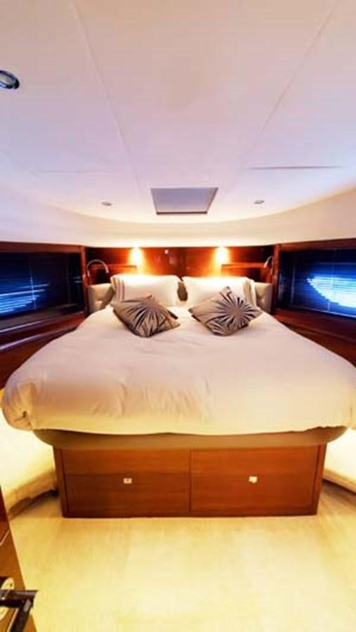a bed with a white bed spread aboard AQUA CHAMELEON Yacht for Sale