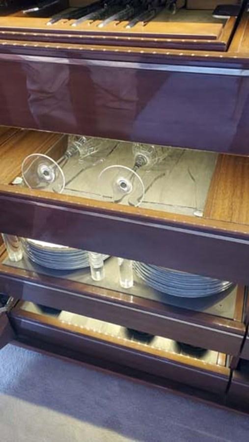 a glass case with a shelf of plates and bowls aboard AQUA CHAMELEON Yacht for Sale