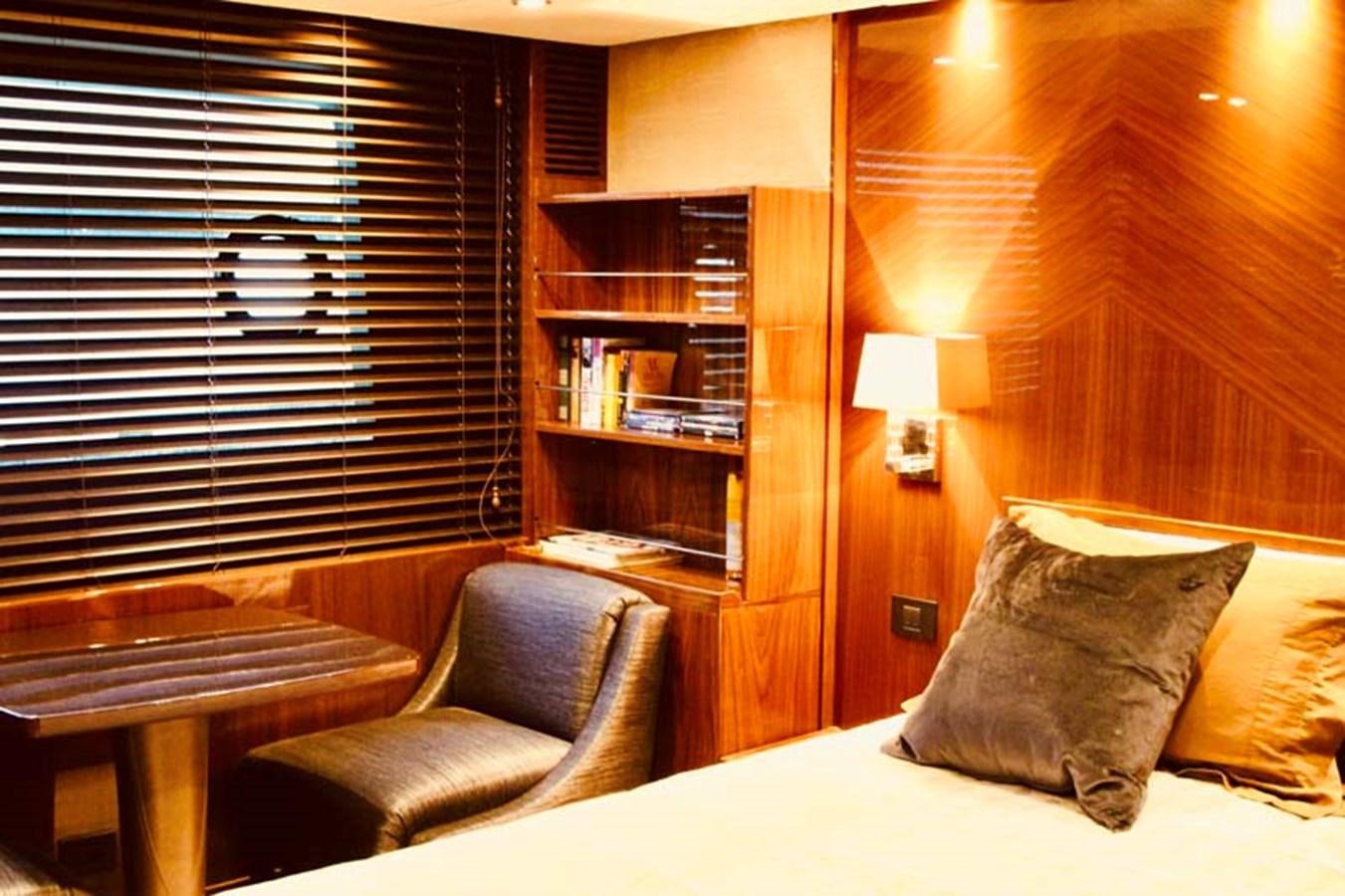 a bed with a chair and a bookcase aboard AQUA CHAMELEON Yacht for Sale