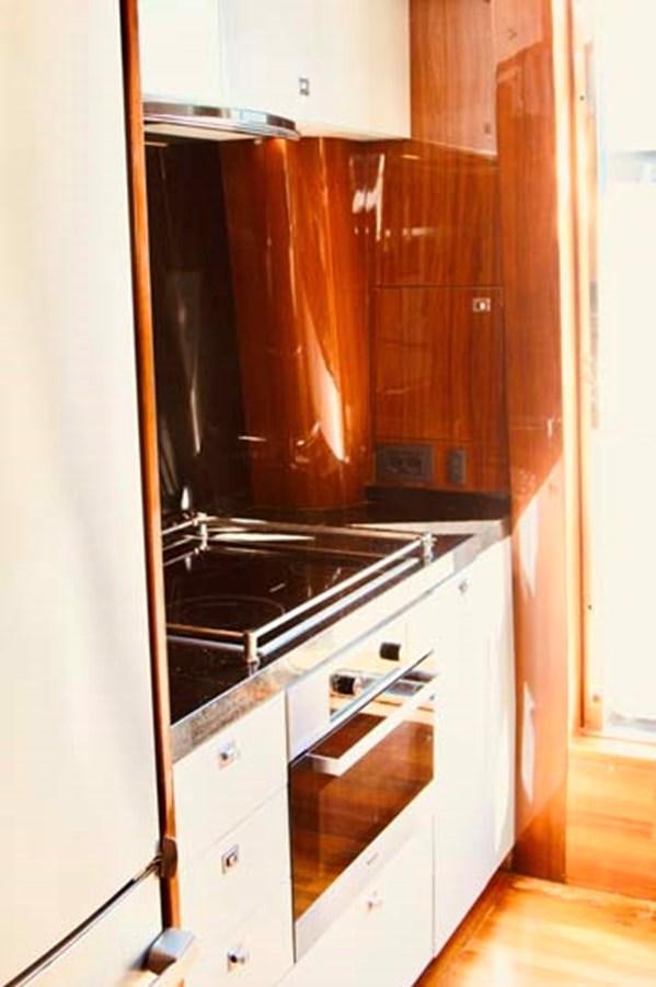 a kitchen with wooden cabinets aboard AQUA CHAMELEON Yacht for Sale