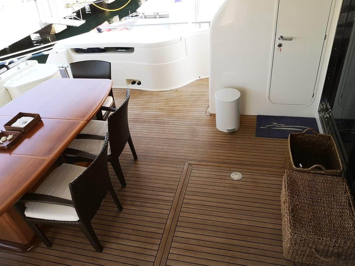 a wooden table and chairs in a room with a white table and a chair aboard RICACHA 2012 FERRETTI 830 @ ACAPULCO Yacht for Sale