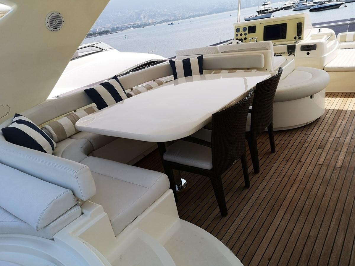 a boat with a table and chairs on a deck aboard RICACHA 2012 FERRETTI 830 @ ACAPULCO Yacht for Sale