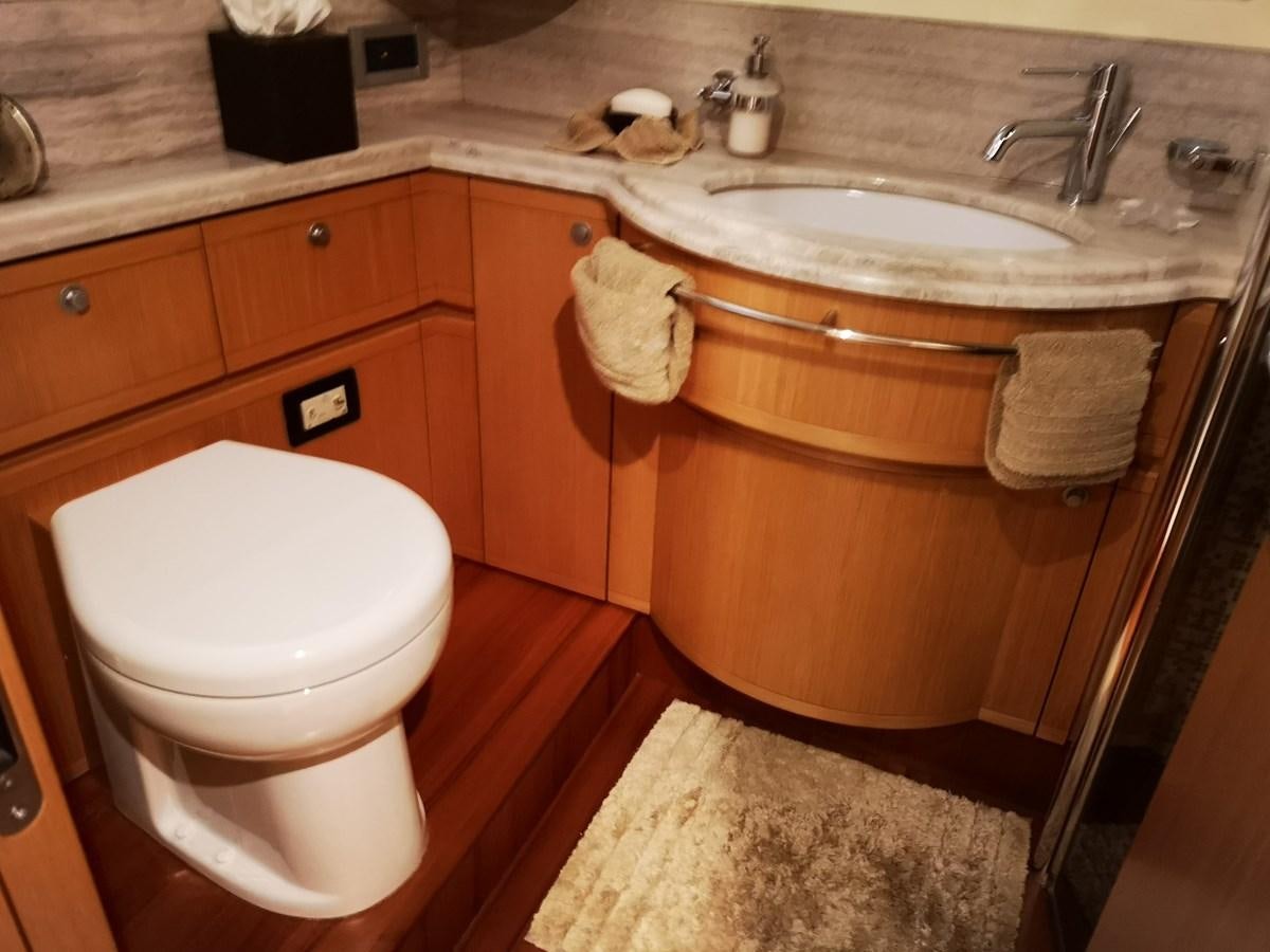 a bathroom with a toilet sink and a mirror aboard RICACHA 2012 FERRETTI 830 @ ACAPULCO Yacht for Sale