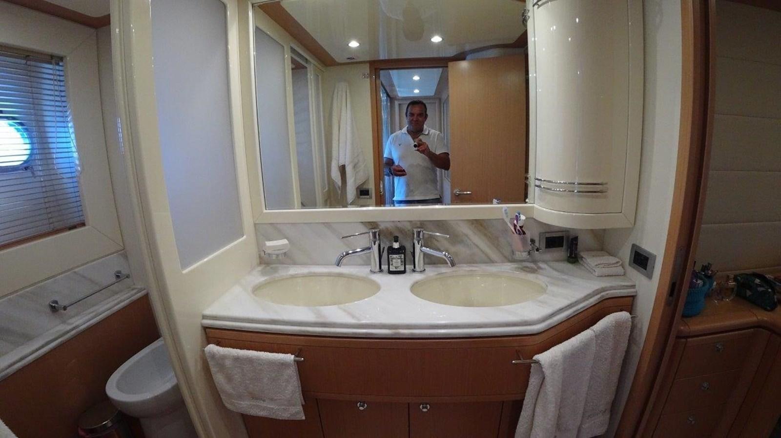 a person taking a picture of himself in a bathroom mirror aboard CHUPRIANA Yacht for Sale