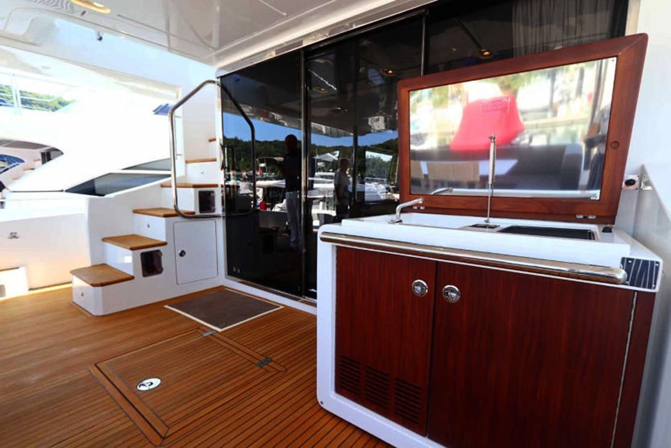 a room with a tv and a table aboard AZIMUT 80 FLYBRIDGE Yacht for Sale