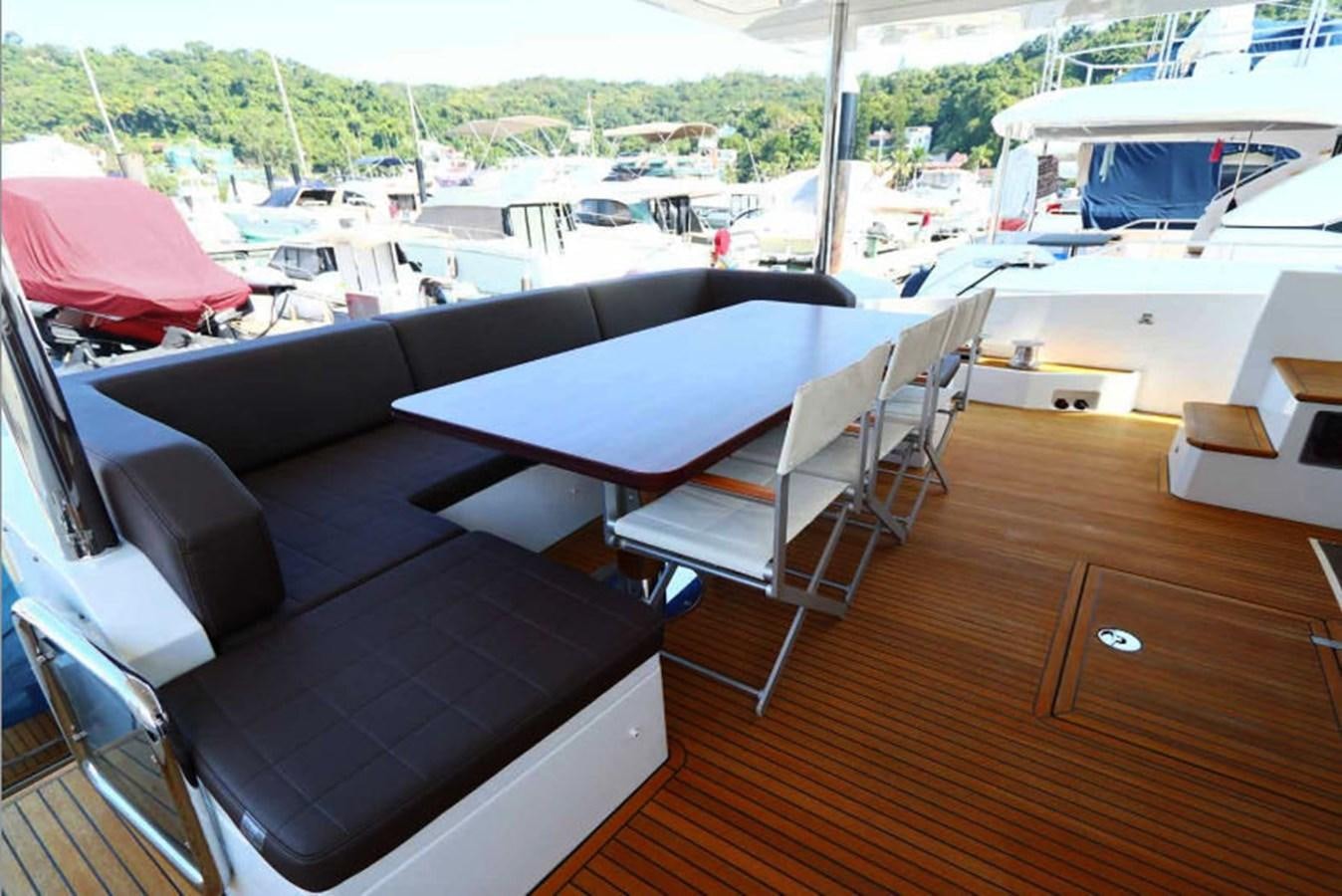 a room with a couch and a table with chairs on it aboard AZIMUT 80 FLYBRIDGE Yacht for Sale