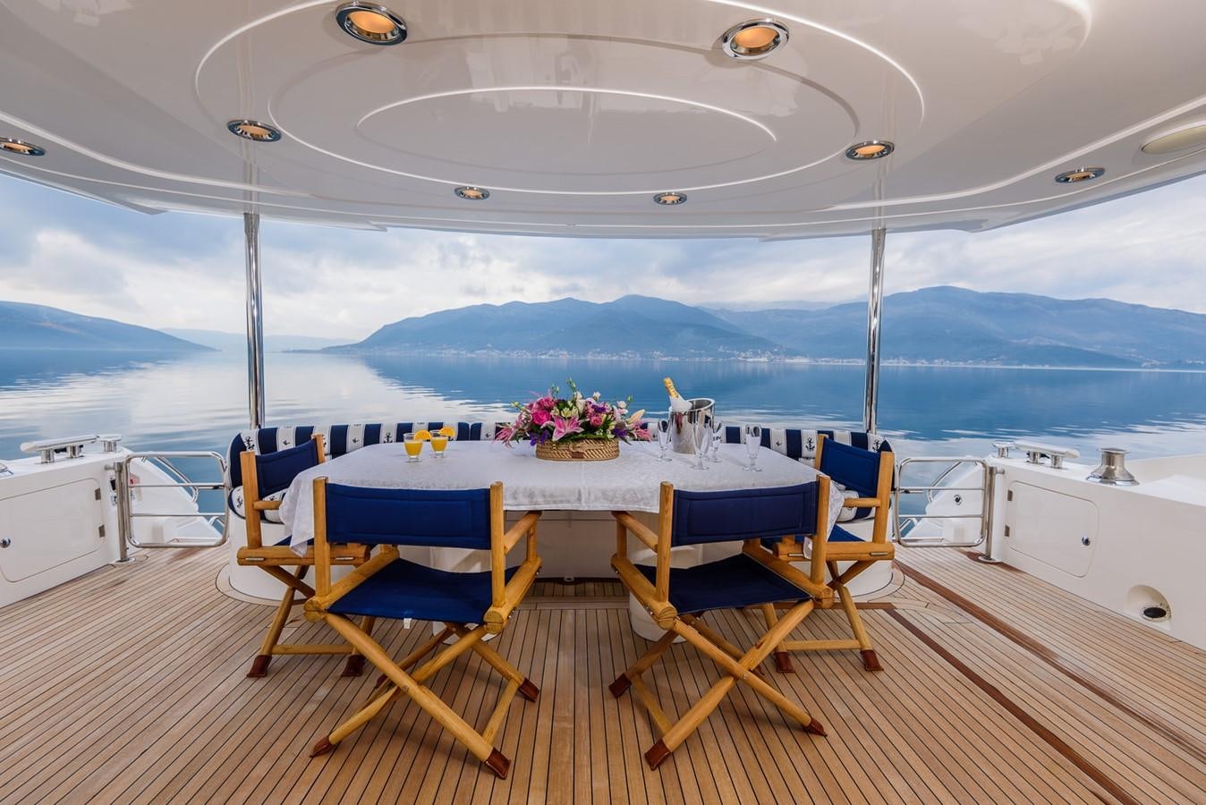 a table with chairs and a view of the ocean aboard BASYA NICOLI Yacht for Sale