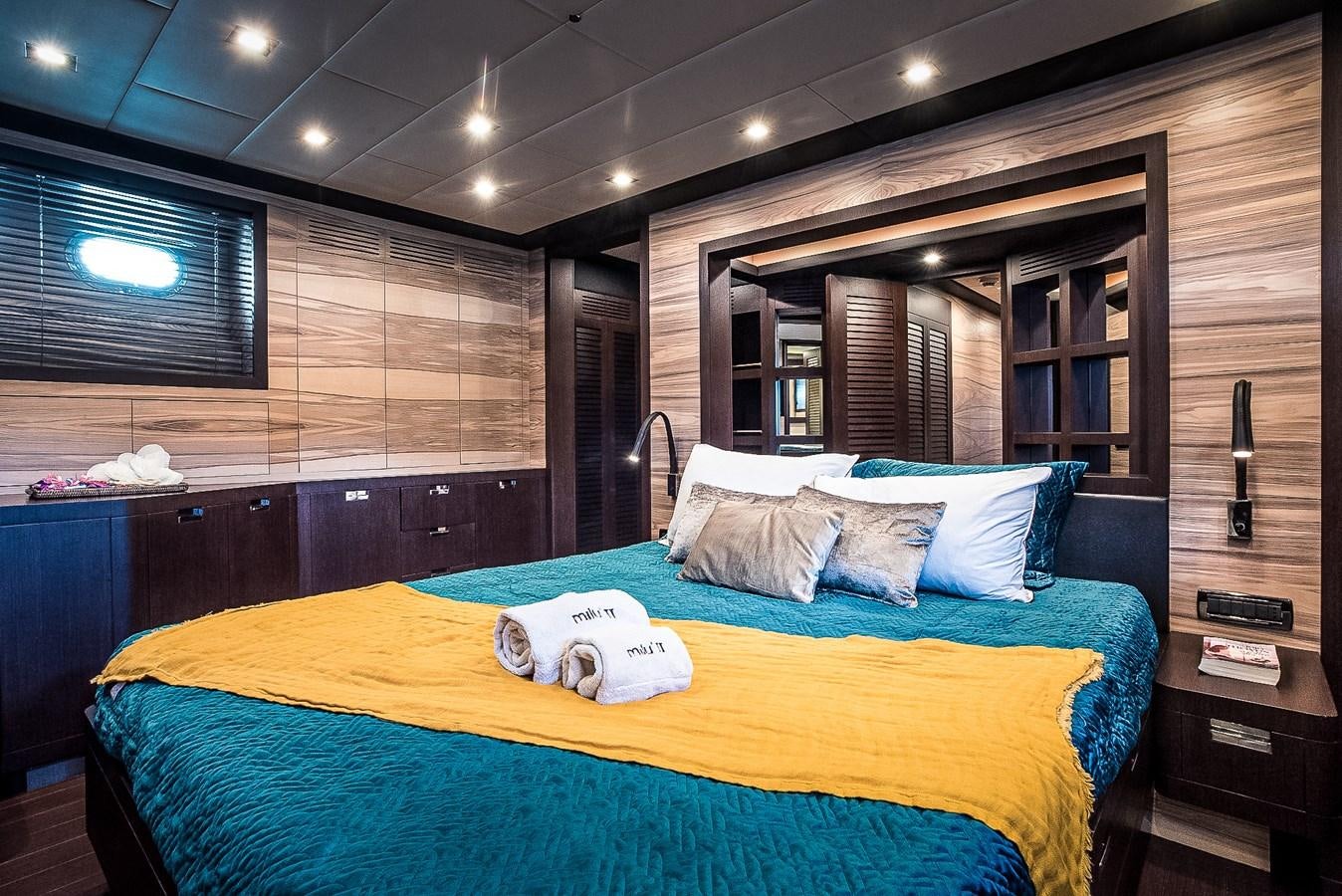 a bed with a blue comforter aboard MILU II Yacht for Sale