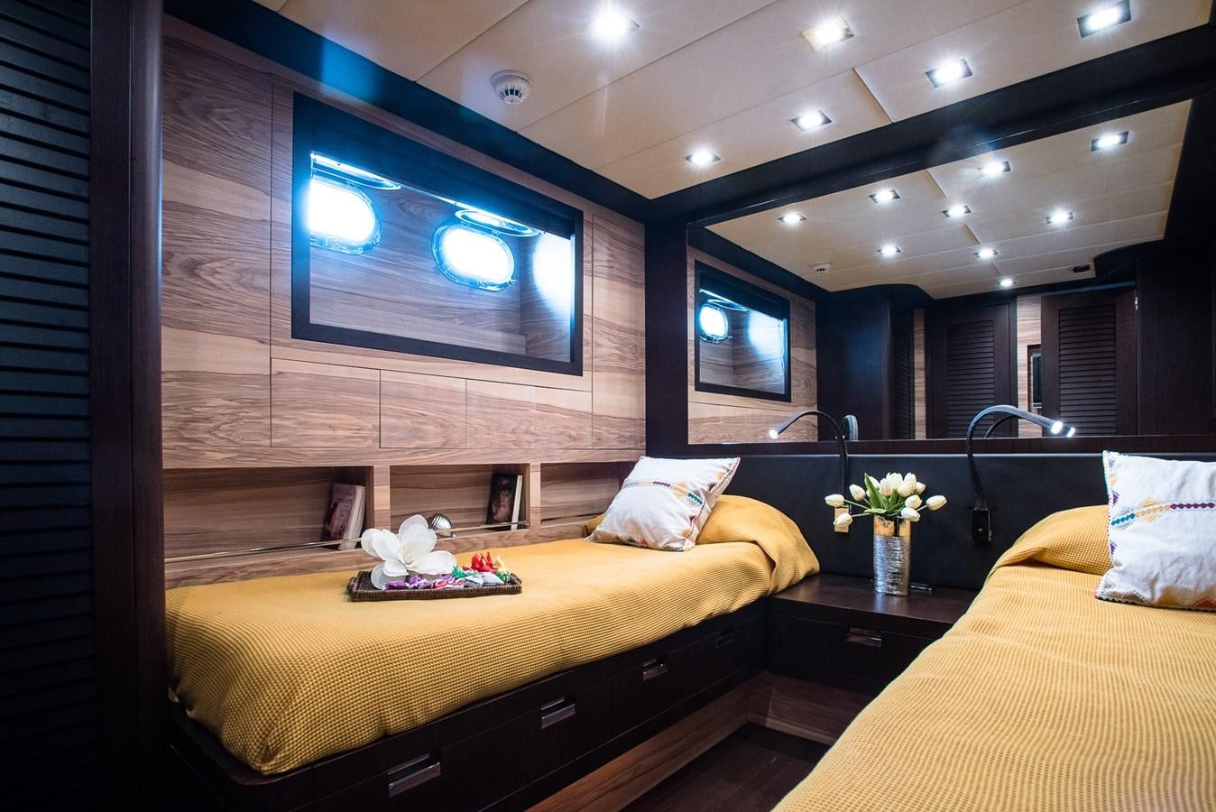 a room with two beds and a tv on the wall aboard MILU II Yacht for Sale
