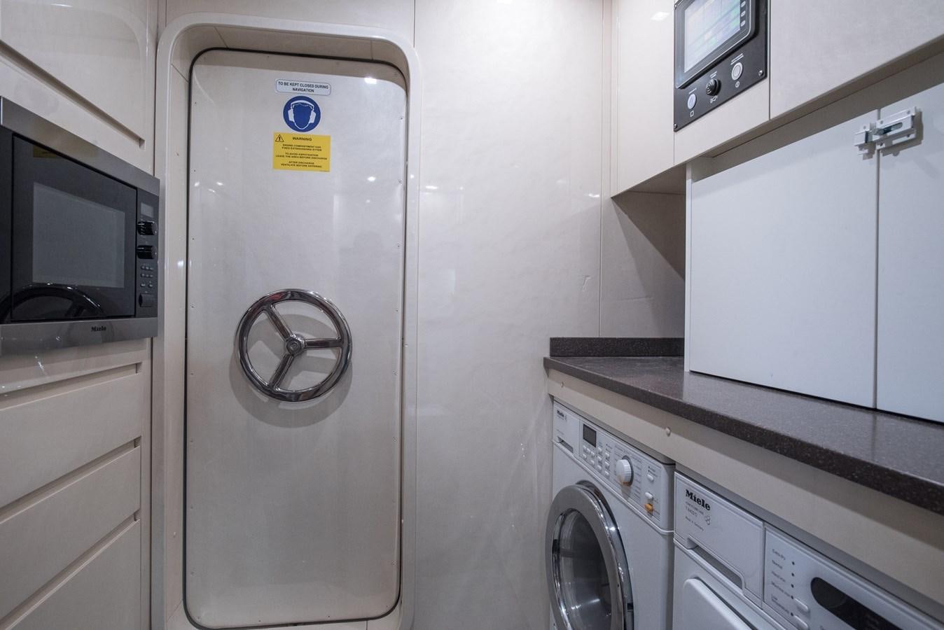 a white laundry room with washing machines aboard MILU II Yacht for Sale