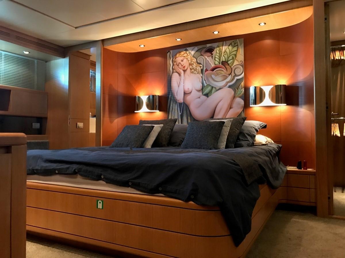 a bed with a painting on the wall aboard LADY LO OF LONDON Yacht for Sale