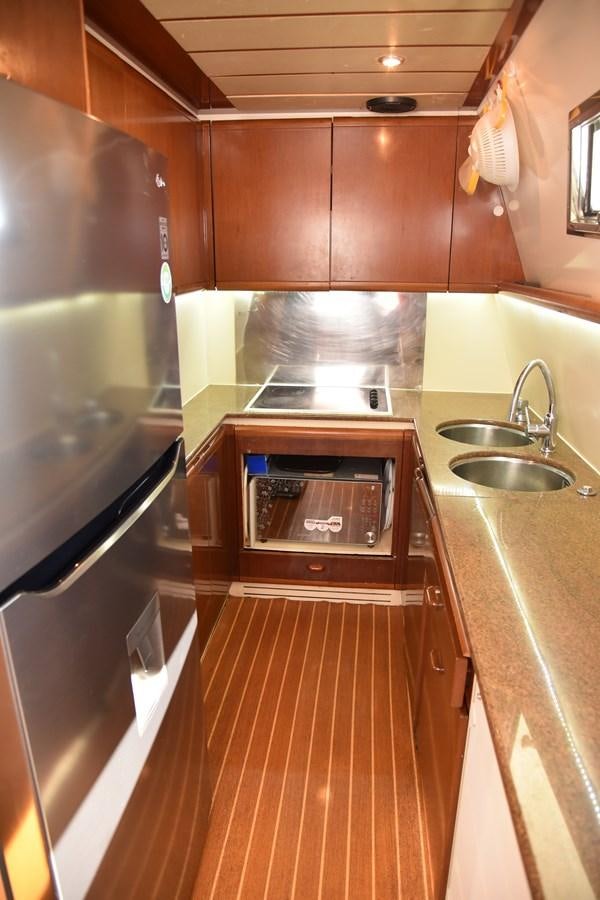 a kitchen with wooden cabinets aboard SANTA MARIA III Yacht for Sale