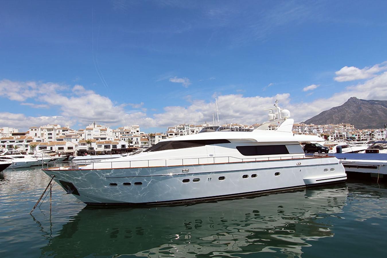 a white yacht in a harbor aboard JAD Yacht for Sale