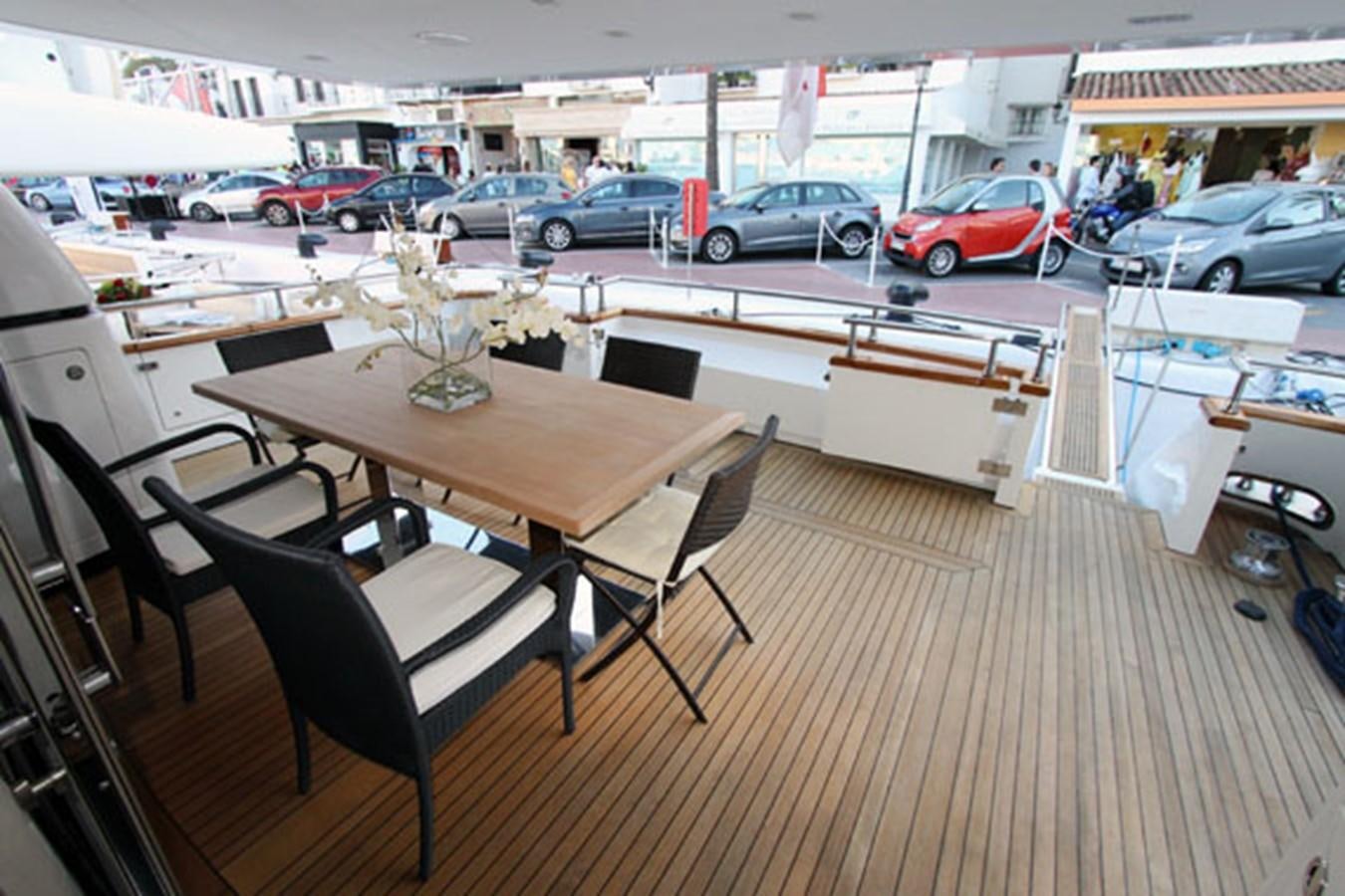 a table with chairs and a glass vase on it aboard JAD Yacht for Sale