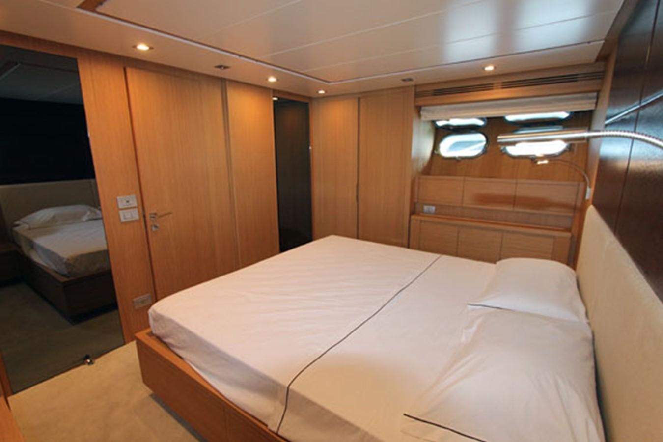 a room with a bed and a dresser aboard JAD Yacht for Sale