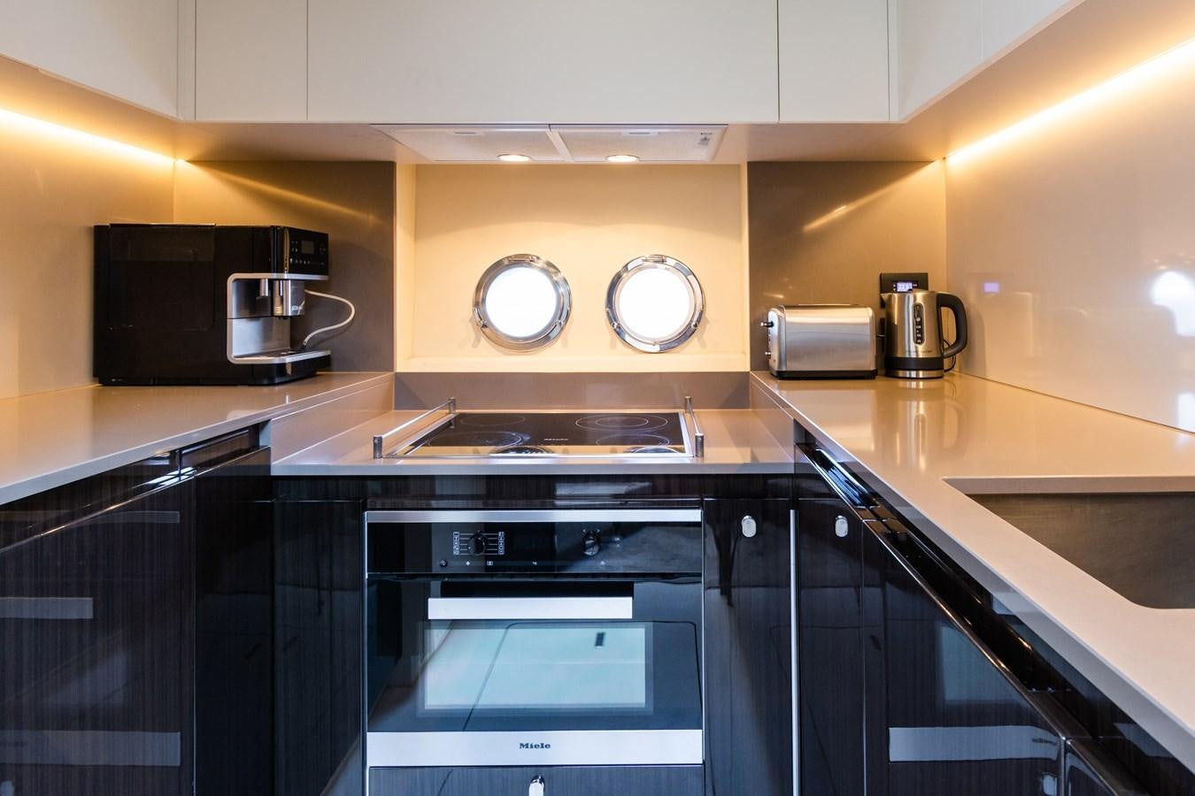 a kitchen with black appliances aboard YACHTI ANA Yacht for Sale