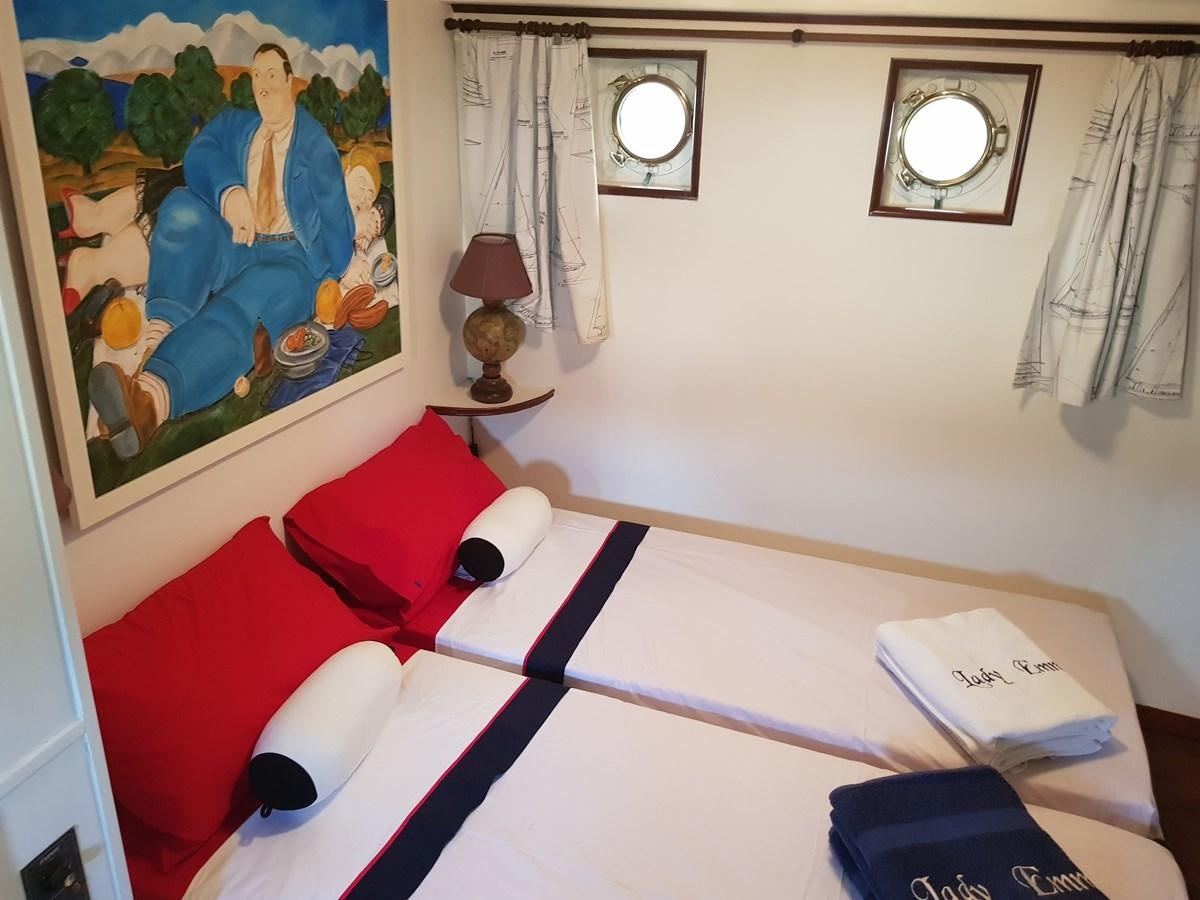a bed with a painting on the wall aboard LADY EMMA Yacht for Sale