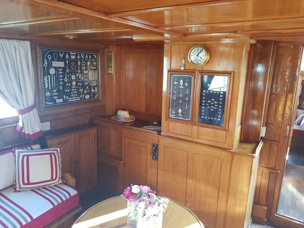 a room with a table and a clock aboard LADY EMMA Yacht for Sale