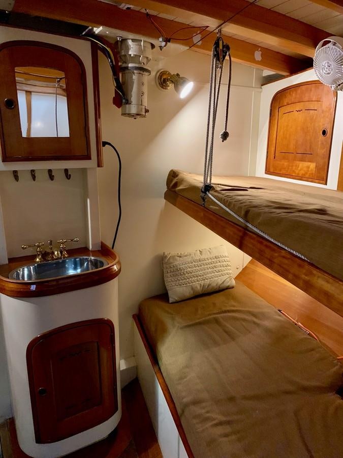 a small bathroom with a sink and a bed aboard WILD HORSES Yacht for Sale