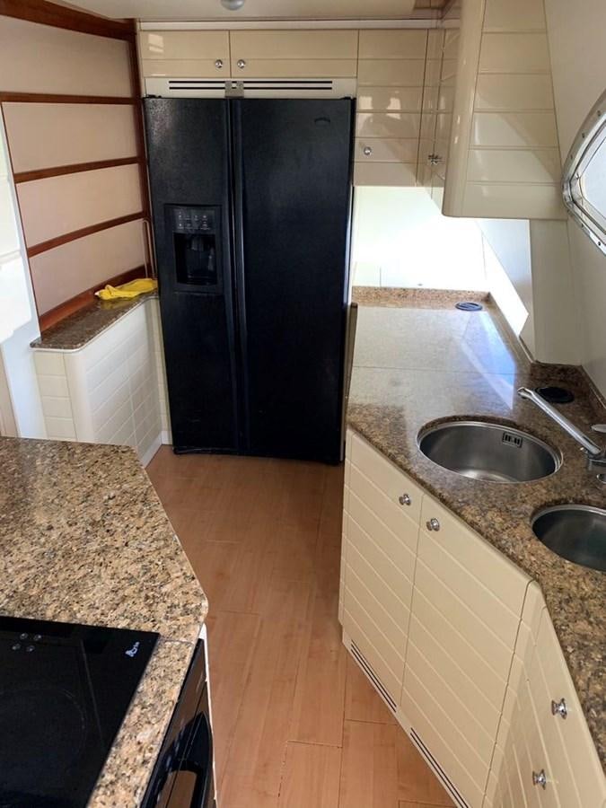 a kitchen with black appliances aboard MARIELA Yacht for Sale