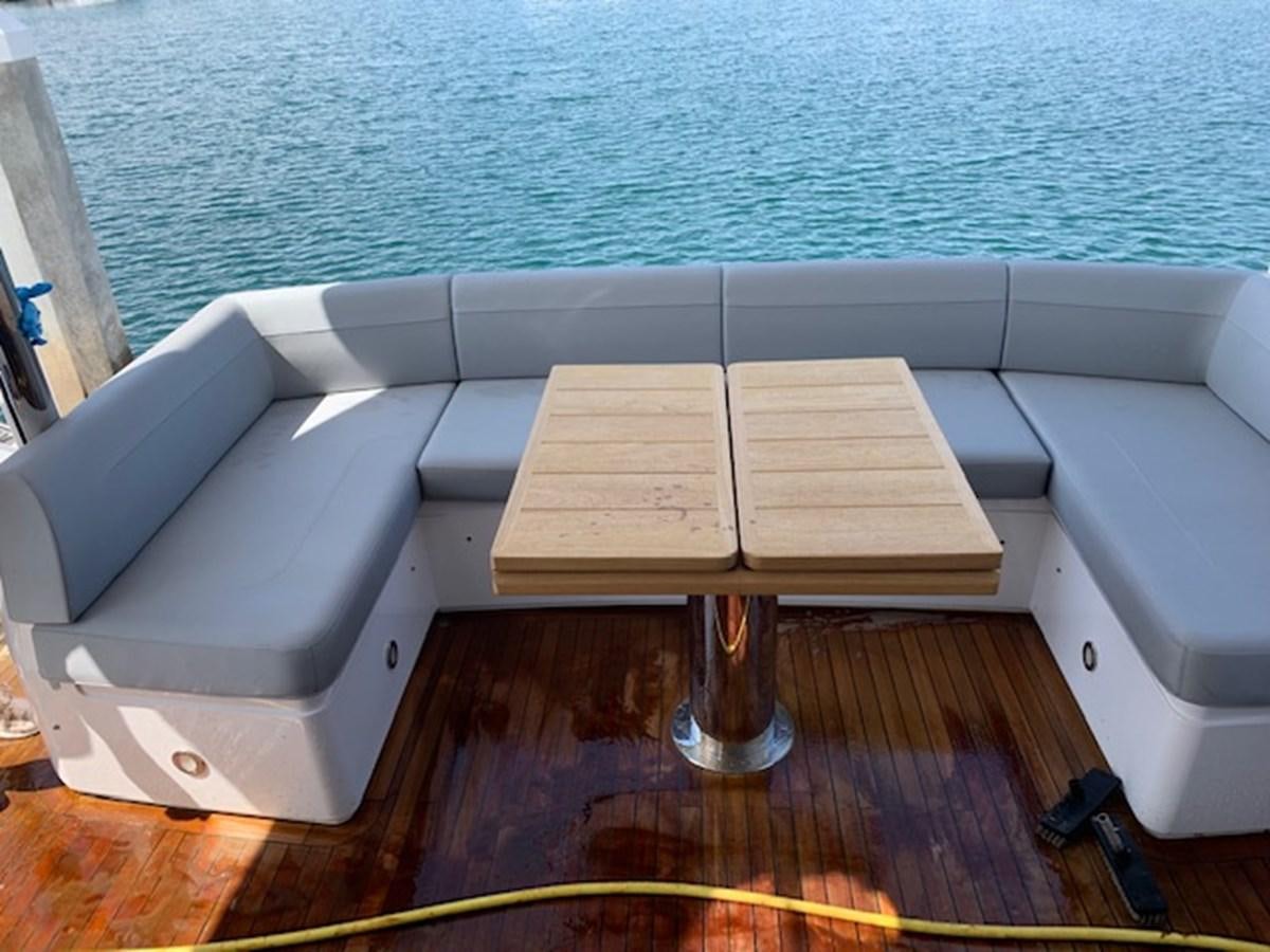a group of wooden tables on a deck by the water aboard SEA SCAPE Yacht for Sale