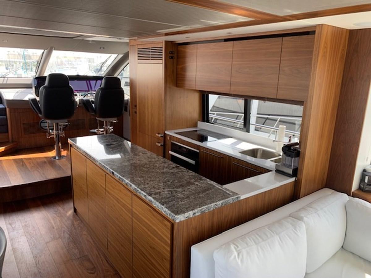 a kitchen with a bar and a table aboard SEA SCAPE Yacht for Sale