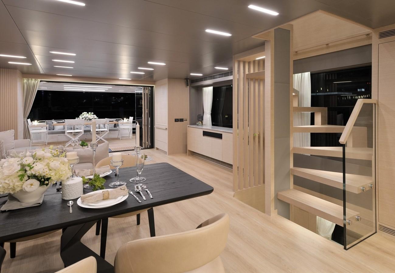 a modern looking kitchen with a glass table and a large window aboard FD75  709 Yacht for Sale