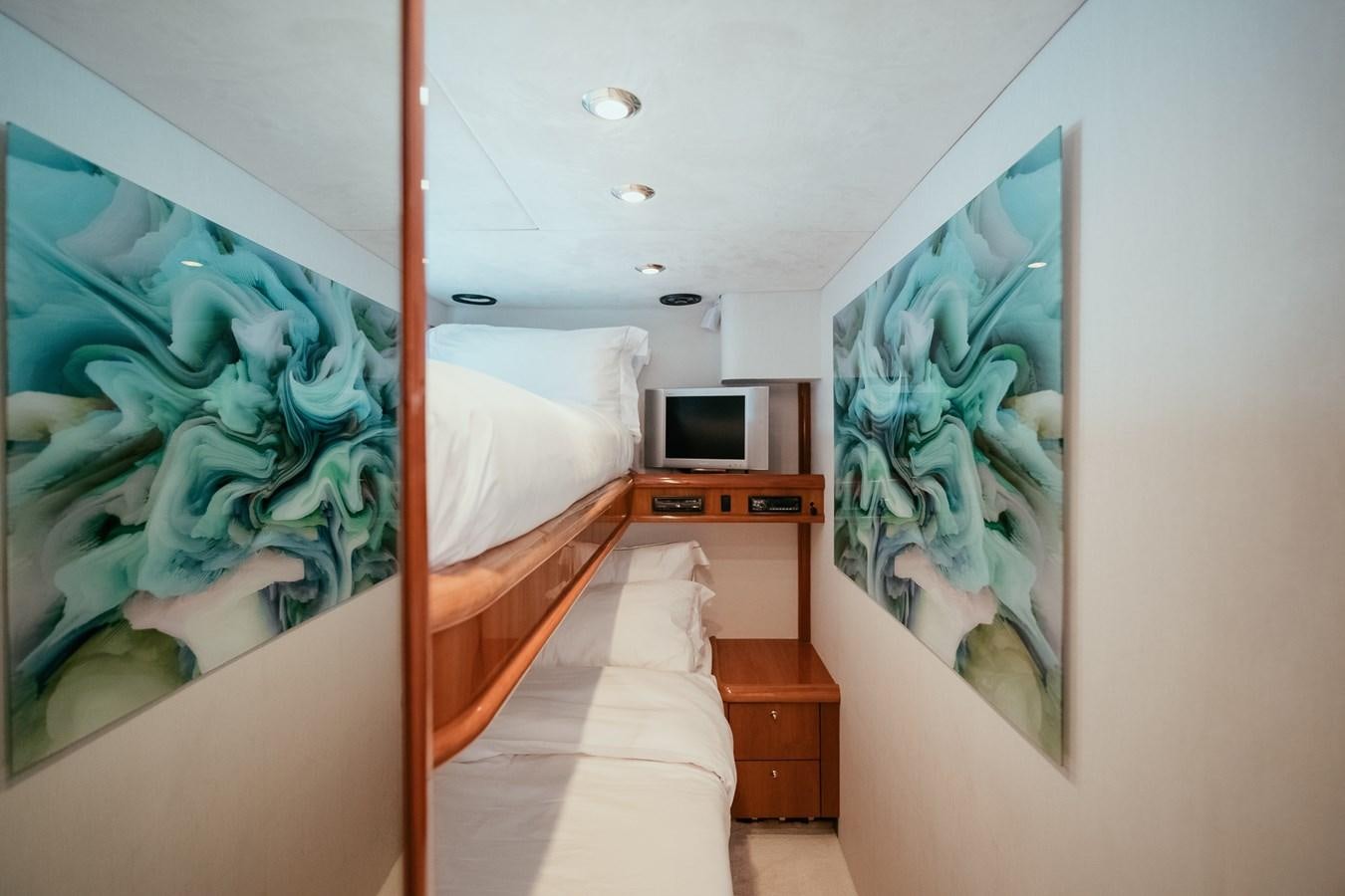 a bedroom with a bed and a desk aboard HOURI Yacht for Sale